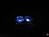 a pair of blue sapphires on a black surface