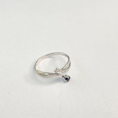 un gros plan d'une bague posée sur une surface blanche, ornée d'un diamant noir