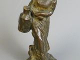 bronze figurine of a woman holding a basket of flowers