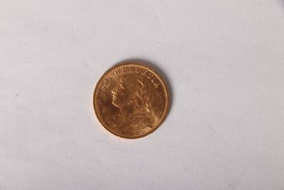 gros plan d'une pièce d'or sur une surface blanche