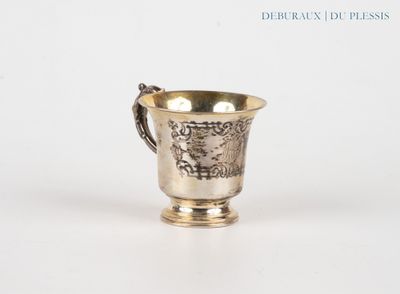 a silver cup with a handle on a white surface