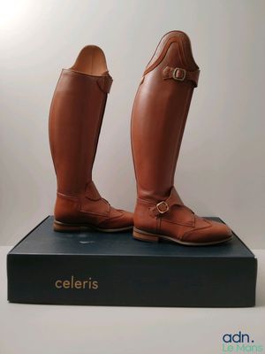 the pair of brown boots are sitting on top of a black box