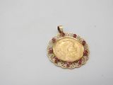 a gold coin with ruby stones in the center of it