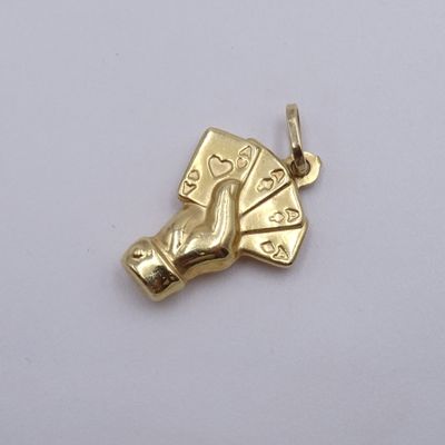 une image représentant un pendentif en or orné de cartes à jouer