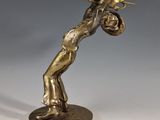 statue en laiton représentant un homme jouant de la trompette, posée sur un socle