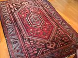 someone is holding a rug on a wooden floor in a room