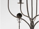 wrought iron candelabra with five candles and a bird on the top