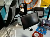 a desk with a monitor, keyboard, mouse, and other items on it