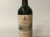 an old bottle of wine sitting on top of a white table