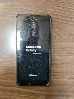 un Samsung Galaxy S8 cassé posé sur une table en bois