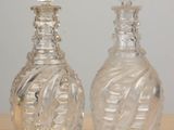 two glass bottles sitting on top of a wooden table