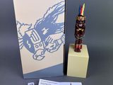 a small statue of a person on a pedestal next to a book