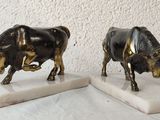 two figurines of a bull and a cow on a marble base