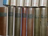 several books are stacked on top of each other on a shelf
