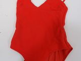 a red one piece swimsuit on a white surface
