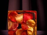 a glass block filled with red and yellow petals
