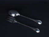 two spoons and a fork on a black surface