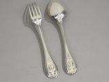 two silver spoons and a fork on a table