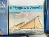 several books on a shelf with a boat in the background