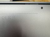 the back of a silver laptop with a small hole in the middle