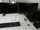 un bureau équipé de deux écrans et d'un clavier