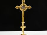 a gold cross on a white table with a black background