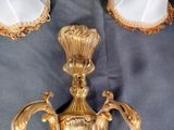 a gold candle holder on a table with two lamps on it
