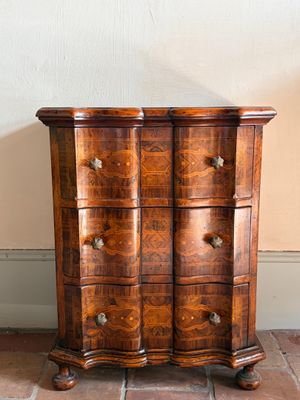 une petite commode posée à même le sol dans une pièce