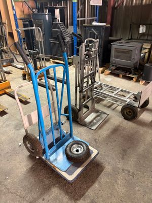 a blue hand truck with wheels in a warehouse
