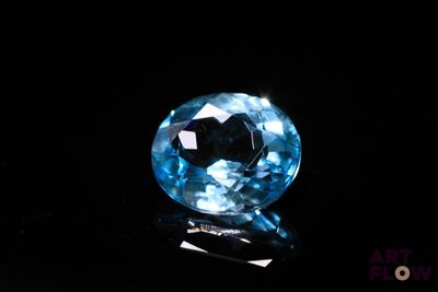 a close up of a blue diamond on a black surface