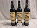 trois bouteilles de vin posées sur une table, à côté d'une étiquette de prix
