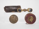 three different types of binoculars and a coin on a white surface