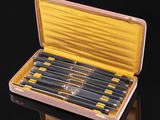 six knives in a wooden case on a black surface