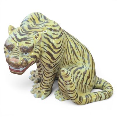 a statue of a tiger sitting on a white surface