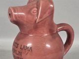 a pink pottery jug with a dog on it