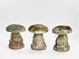 trois champignons de tailles différentes empilés les uns sur les autres sur une surface blanche