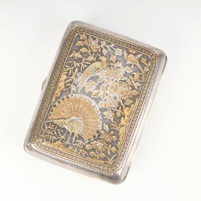 an antique silver and gold cigarette case with a floral design