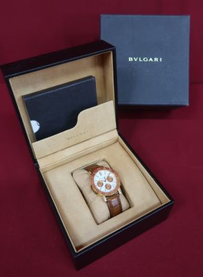 an image of a watch in a box on a red surface
