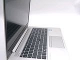 a silver laptop computer sitting on a white surface
