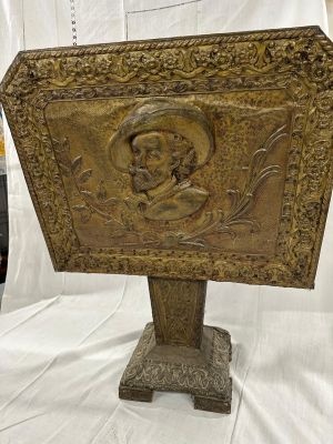 une photo d'une plaque en bois sur laquelle figure le portrait d'un homme