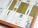 a picture of a tile with flowers and leaves on it