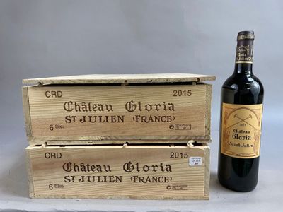 two bottles of wine sitting next to a wooden box on top of a table
