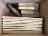 a lot of books in a cardboard box on the floor