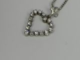 un pendentif en diamant en forme de cœur, suspendu à une chaîne, posé sur une table