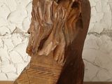a wooden sculpture of a man ' s head on a table