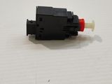a close up of a red and black switch on a white surface