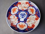 une assiette orange et bleue ornée de fleurs, posée sur une table
