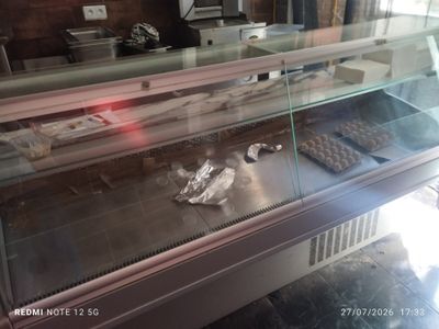 a glass display case with donuts and other pastries in it