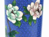 a blue vase with white flowers on it and a black vase next to it