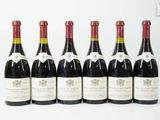 six bouteilles de vin sont alignées sur une surface blanche